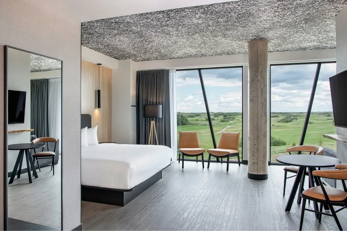 Dakota Dunes Resort, Whitecap — a guest room with tall windows opening onto the golf course